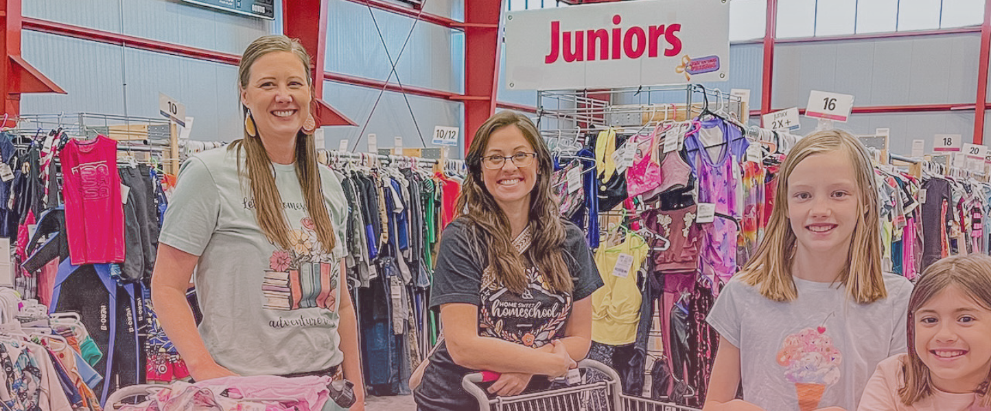 Two friends shop together—one mom wears her baby girl—as they find great deals at their local JBF sale.